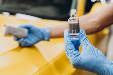 Man at car service doing car ceramic procedure