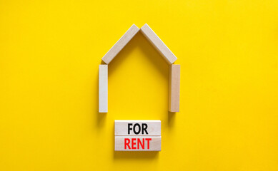Fototapeta na wymiar House for rent symbol. Concept words 'For rent' on wooden blocks near miniature house. Beautiful yellow background, copy space. Business and house for rent concept.