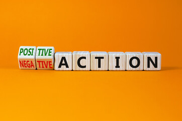 Positive or negative action symbol. Turned cubes and changed words negative action to positive action. Beautiful orange background, copy space. Business positive or negative action concept.