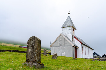 Fototapeta na wymiar Beautiful Church in the village of Videreidi in the Fareo islands, covered in mist 