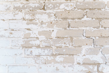 Brick wall texture with faded white paint.