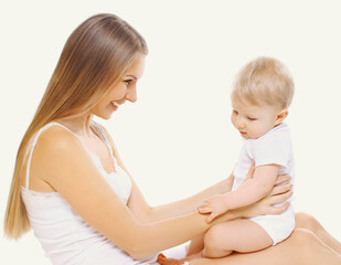 Portrait of happy cheerful smiling mother and baby playing together on a white background