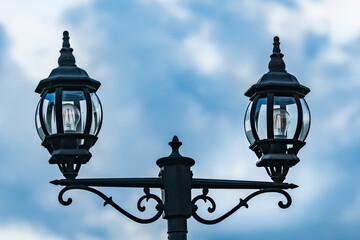 Street lamp close-up against the sky with clouds in summer
