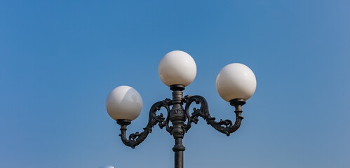Fototapeta na wymiar Street lamp close-up against the blue sky in summer