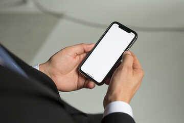 businessman man in a jacket and suit holds a smartphone in his hands. Electronics are in human hands. Concept - digital era