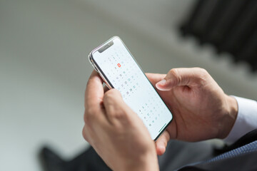 businessman man in a jacket and suit holds a smartphone in his hands. Electronics are in human hands. Concept - digital era