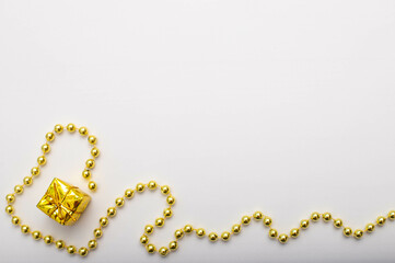 Gift box of a gold colour and gold garland on white background