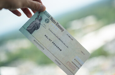Blurred COVID-19 economic Stimulus American rescue program check on blurred background. Relief program concept.