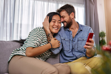 a young man and his girlfriend looking at their shared photos on the phone