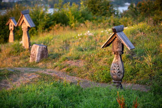 Wooden crosses in old russian cemetery on top the hill over river and forest.