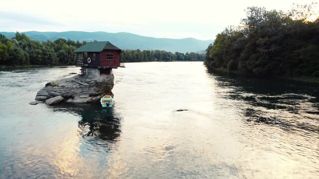Small wooden cabin on a rock in the middle of river Drina, Serbia.	
