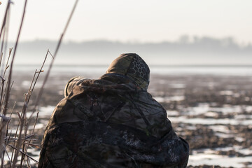 Masked wildlife photographer waiting for game in a game refuge, hidden and well hidden like a...