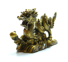 figurine of a dragon holding a pearl in its paw on white background