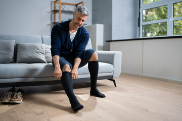 Man Putting On Medical Compression Stockings