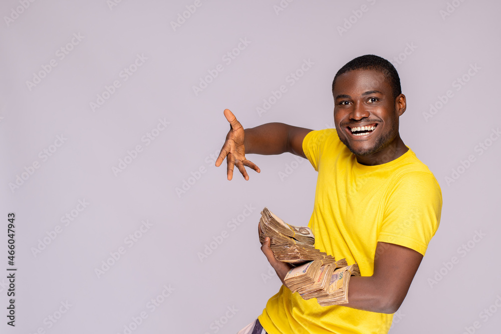 Wall mural young nigerian man holding a lot of cash feeling excited and happy