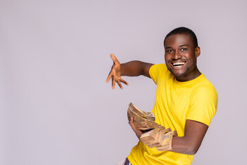 young nigerian man holding a lot of cash feeling excited and happy