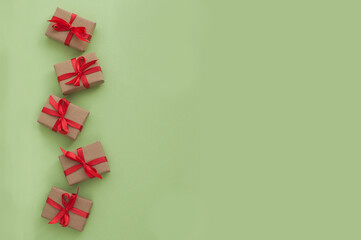small gifts with red ribbons on a green background with space for text