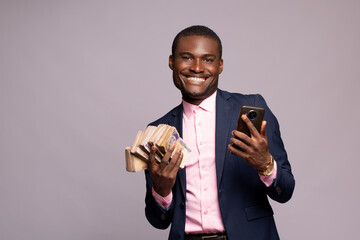 excited young black man holding some money and his phone