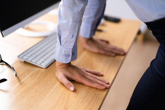 Woman Stretching Arms At Office Desk