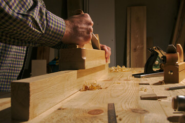 Ręczna praca struganie dębowego drewna przy pomocy drewnianego tradycyjnego strugu. - obrazy, fototapety, plakaty