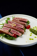 Slices of tuna ahi with fresh vegetable salad on a plate. 