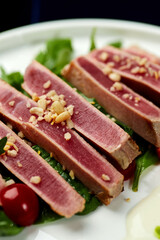 Slices of tuna ahi with fresh vegetable salad on a plate. 