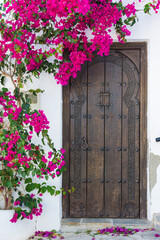 Fototapeta na wymiar Beautiful wooden, front door of a house decorated with flowers
