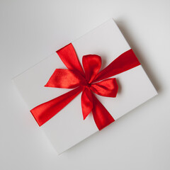 White box, bow and ribbon. Gift on the table.