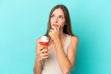 Young Lithuanian woman with cornet ice cream isolated on blue background having doubts