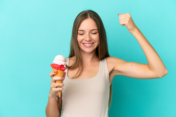 Young Lithuanian woman with cornet ice cream isolated on blue background doing strong gesture