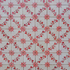 Azulejos ornate pattern for design or backdrop. Abstract background from old white decorative tiles with painted red brown flowers. Ornamental art form, of traditional Portuguese, glazed ceramic tiles