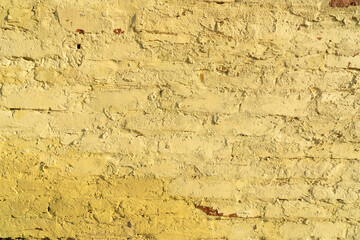 Old brick walls painted in ocher color. Creative vintage background.