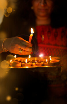 Woman holding a tray of diya 