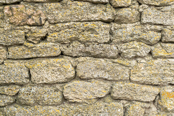 The fortress wall is made of natural stone. Ancient limestone stone. Creative vintage background. Ukraine. Belgorod - Dnestrovsky.