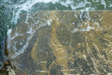 Sea waves run into a concrete pier. Night sea.