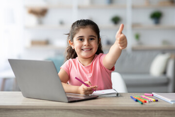 Little Arab Girl Showing Thumb Up While Study With Laptop At Home