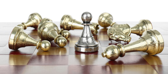 Fototapeta na wymiar Silver pawn among fallen golden chess pieces on wooden board against white background