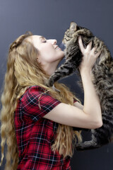 The girl squeezes a tabby fluffy cat. Favorite pet. Love for cats