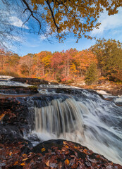 Fototapeta na wymiar Shohola Falls in the Pennsylvania Poconos on a beautiful fall morning surrounded by peak fall foliage. Waterfalls in the fall.