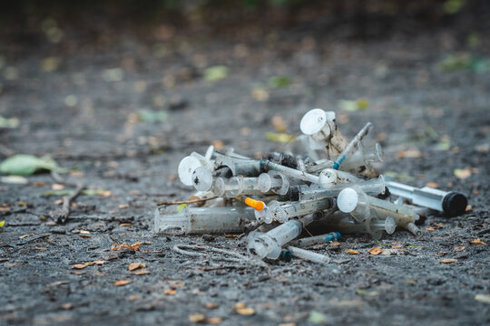 bunch of used dirty syringe leaved after drug injection lying on ground outdoor