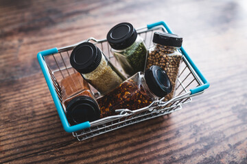 spices and seasonings in matching spice jars in ngrocery shopping basket, simple vegan ingredients and flavoring your dishes