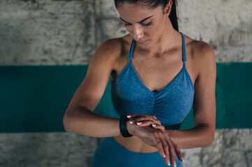 Woman in sportswear checks fitness and health tracking on her smartwatch after training