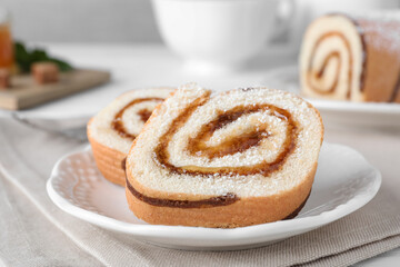 Tasty cake roll with jam on white table, closeup