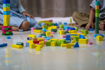 Obraz premium Children play wooden blocks with geometric shapes.