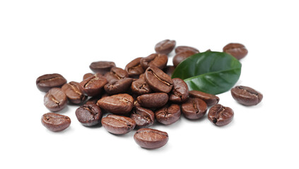Pile of roasted coffee beans with fresh leaf on white background