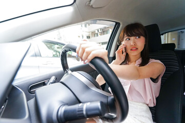 スマホを使いながら運転する女性