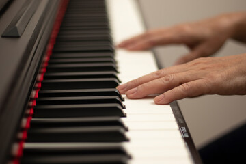 Obraz na płótnie Canvas Female hands play the electric piano, Hand and piano keys close up