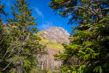 霞沢岳、乗鞍岳、上高地、穂高岳などを見るために、長野県松本市の晩秋の雪が積もる焼岳を登山する風景 Scenery of climbing Mt. Yakedake with snow in late autumn in Matsumoto, Nagano Prefecture to see Mt. Kasumisawa, Mt. Norikura, Kamikochi and Mt. Hodaka