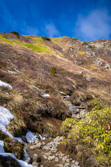 霞沢岳、乗鞍岳、上高地、穂高岳などを見るために、長野県松本市の晩秋の雪が積もる焼岳を登山する風景 Scenery of climbing Mt. Yakedake with snow in late autumn in Matsumoto, Nagano Prefecture to see Mt. Kasumisawa, Mt. Norikura, Kamikochi and Mt. Hodaka