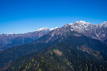 霞沢岳、乗鞍岳、上高地、穂高岳などを見るために、長野県松本市の晩秋の雪が積もる焼岳を登山する風景 Scenery of climbing Mt. Yakedake with snow in late autumn in Matsumoto, Nagano Prefecture to see Mt. Kasumisawa, Mt. Norikura, Kamikochi and Mt. Hodaka